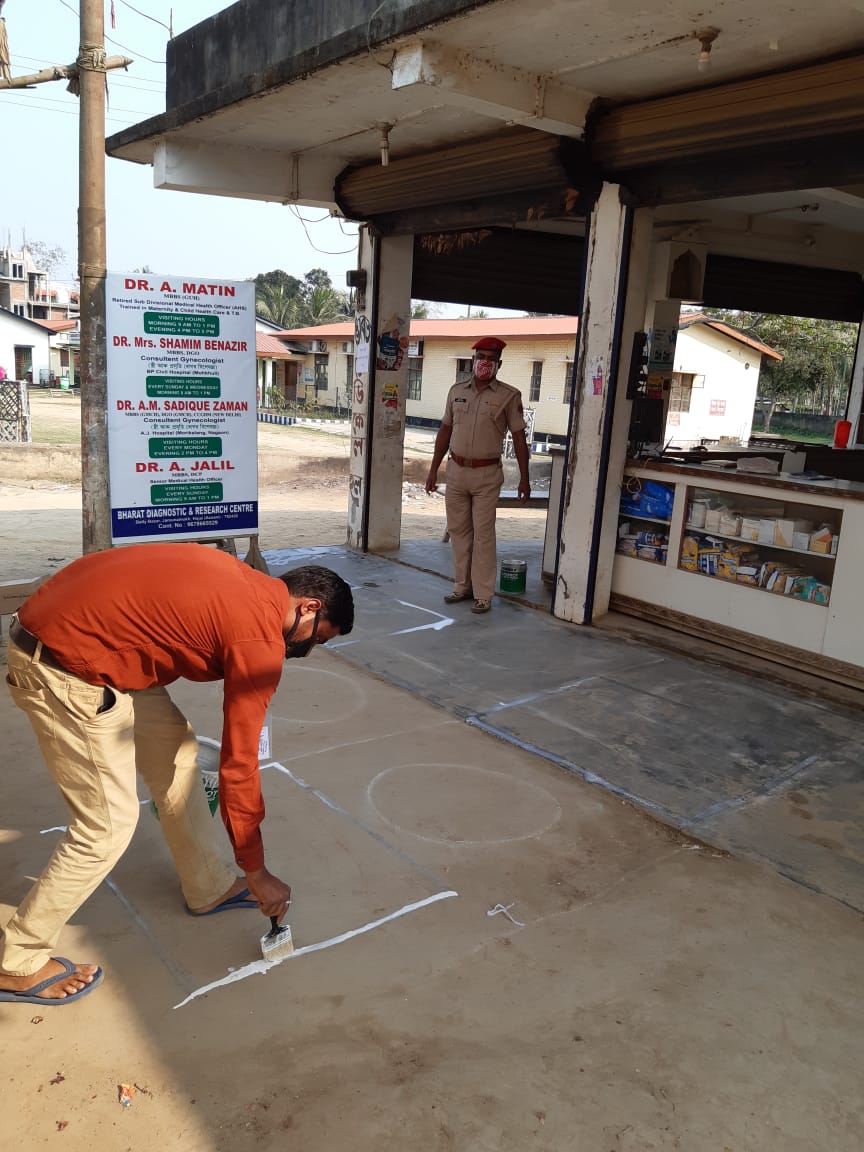  দোকান–ফাৰ্মাচীৰ পৰা লাগতীয়াল সামগ্ৰী ক্ৰয় কৰাৰ সময়ত যাতে শাৰী পাতি থকা ব্যক্তিৰ মাজত কমেও এক মিটাৰ ব্যৱধান থাকে তাৰ কাৰণে অংকন কৰা হৈছে এই ক্ষেত্ৰ।