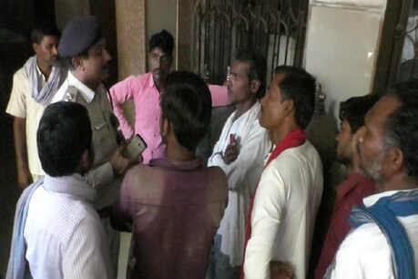 युवक के खुद को आग लगाने पर ग्रामीणों से पूछताछ करते स्थानीय पुलिस अधिकारी