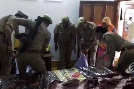 महिला के शव को कब्जे में लेते पुलिसकर्मी
