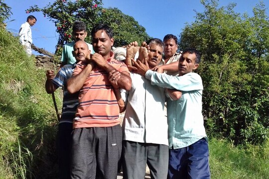 श्रद्धालु को पहाड़ी से रेस्क्यू कर लाते हुए.