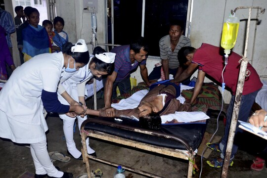 असम स्थित गोलाघाट के एक चाय के बगान में शराब का सेवन करने के बाद अस्पताल में भर्ती पीड़ितों का इलाज करती नर्स. फोटो साभार- पीटीआई