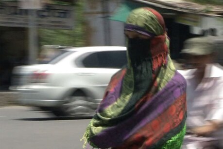 उदयपुर में गर्मी से बचाव करके जाती युवती। फोटो : न्यूज 18 राजस्थान ।