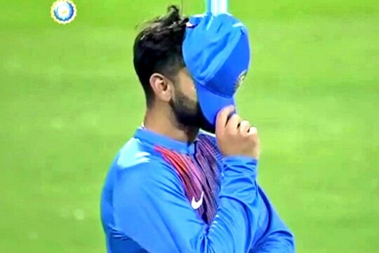 डीआरएस लेने का फैसला गलत होने के बाद अपना चेहरा छुपाते भारतीय कप्तान विराट कोहली.