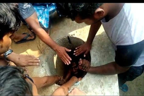 संकरे गढ्ढे में फंसे युवक को बाहर निकालते लोग