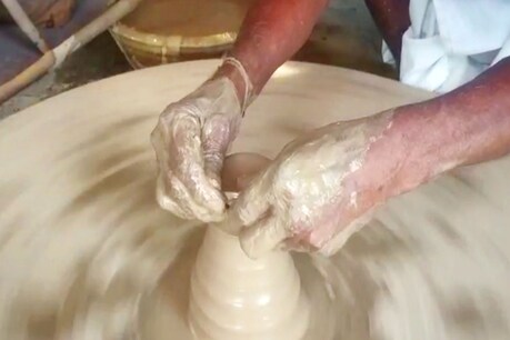 चाक पर मिट्टी के दीये को आकार देता कुम्हार