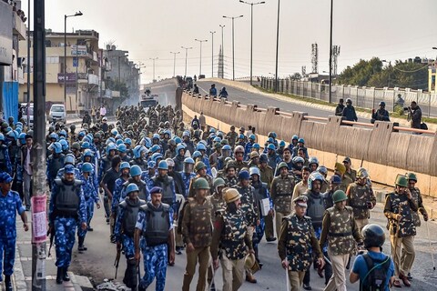 मंगलवार 25 फरवरी को सीएए और एनआरसी के खिलाफ और समर्थन करने वालों में संघर्ष के बाद उत्तर पूर्व दिल्ली में फ्लैग मार्च करते सुरक्षा बलों के जवान. 