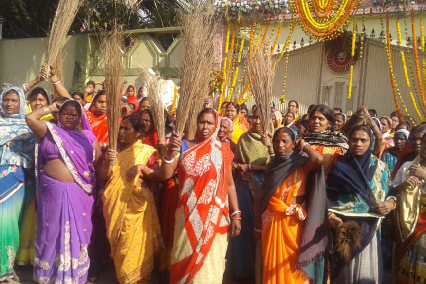 झाड़ू लेकर पुलिस की कार्रवाई का विरोध करतीं महिलाएं
