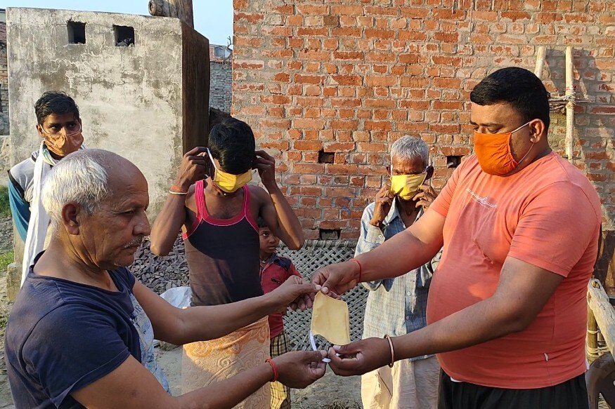 भिदिउरा गांव में ग्रामीणों को नि:शुल्क मास्क उपलब्ध कराए जा रहे हैं. Free masks are being provided to villagers in Bhidiura village.