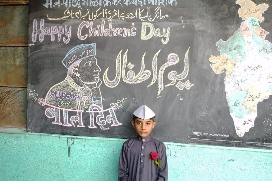 बाल दिवस के मौके पर ब्लैक-बोर्ड के सामने खड़ा एक बच्चा