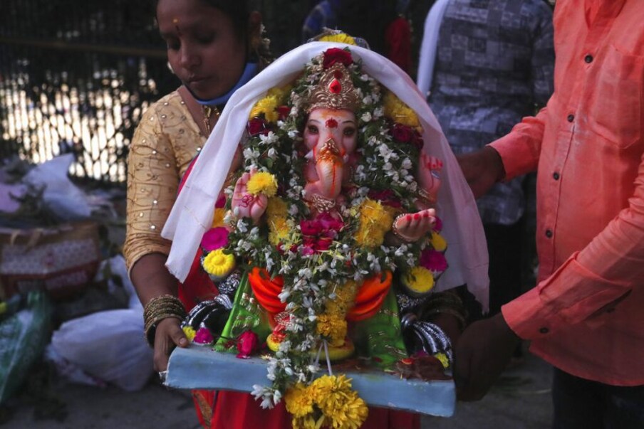  हैदराबाद में दस दिन के गणेश चतुर्थी पर्व के बाद अपने-अपने घरों से भगवान गणेश की मूर्ति का विसर्जन करने हुसैन सागर झील में पहुंचे. (Pic- AP)