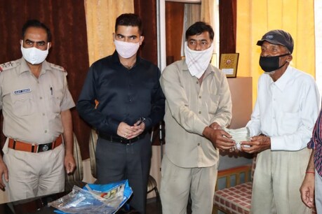 बुजुर्ग को थाने में पुलिसवालों की मौजूदगी में पैसे लौटाता ईमानदार ऑटोचालक.