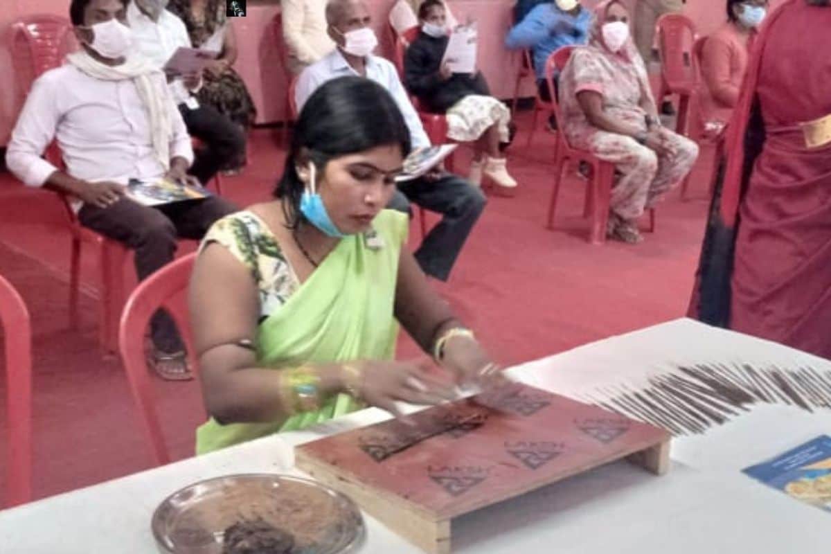 फूलों से अगरबत्ती बनाती महिला