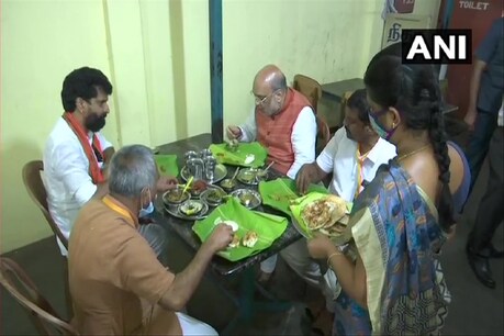 तमिलनाडु में करूर जिले के कृष्णारायापुरम स्थित एक रेस्तरां में भाजपा नेताओं संग खाना खाते अमित शाह. (ANI Twitter/1 April 2021)