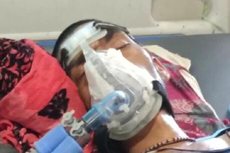 टेप से चिपका ऑक्सीजन मास्क लगाए मरीज़.