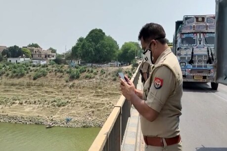 हमीरपुर में यमुना नदी में कई शव तैरते दिखने से हड़कंप मचा है. (Photo:
नदी में शवों की तस्वीर खींचता पुलिसकर्मी)