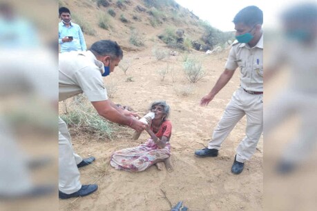 बुजुर्ग महिला को पानी पिलाते पुलिसकर्मी.