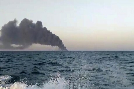 ईरान के सोशल मीडिया पर चल रही तस्वीरों में जीवनरक्षक जैकेट पहने नौसैनिकों को जहाज को निकालते हुए देखा जा सकता है और उनके पीछे आग नजर आ रही है. (फोटो साभारः AP)