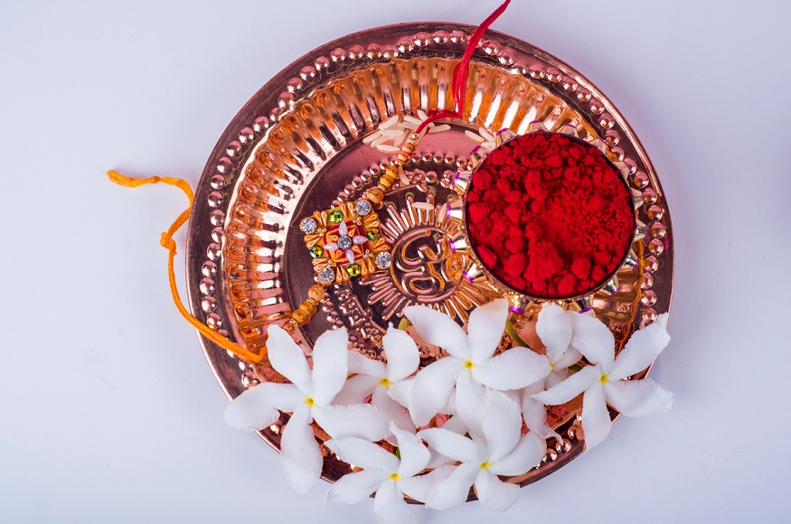  रक्षा बंधन के दिन पूजा की थाली पर गंगा जल छिड़क कर उसमें कुमकुम या रोली रखें. इसी कुमकुम से बहनें भाई का तिलक करती हैं. (Image-Shutterstock)