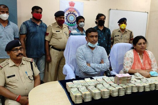दोनों आरोपियों और जब्त की गई रकम के साथ पुलिस टीम.