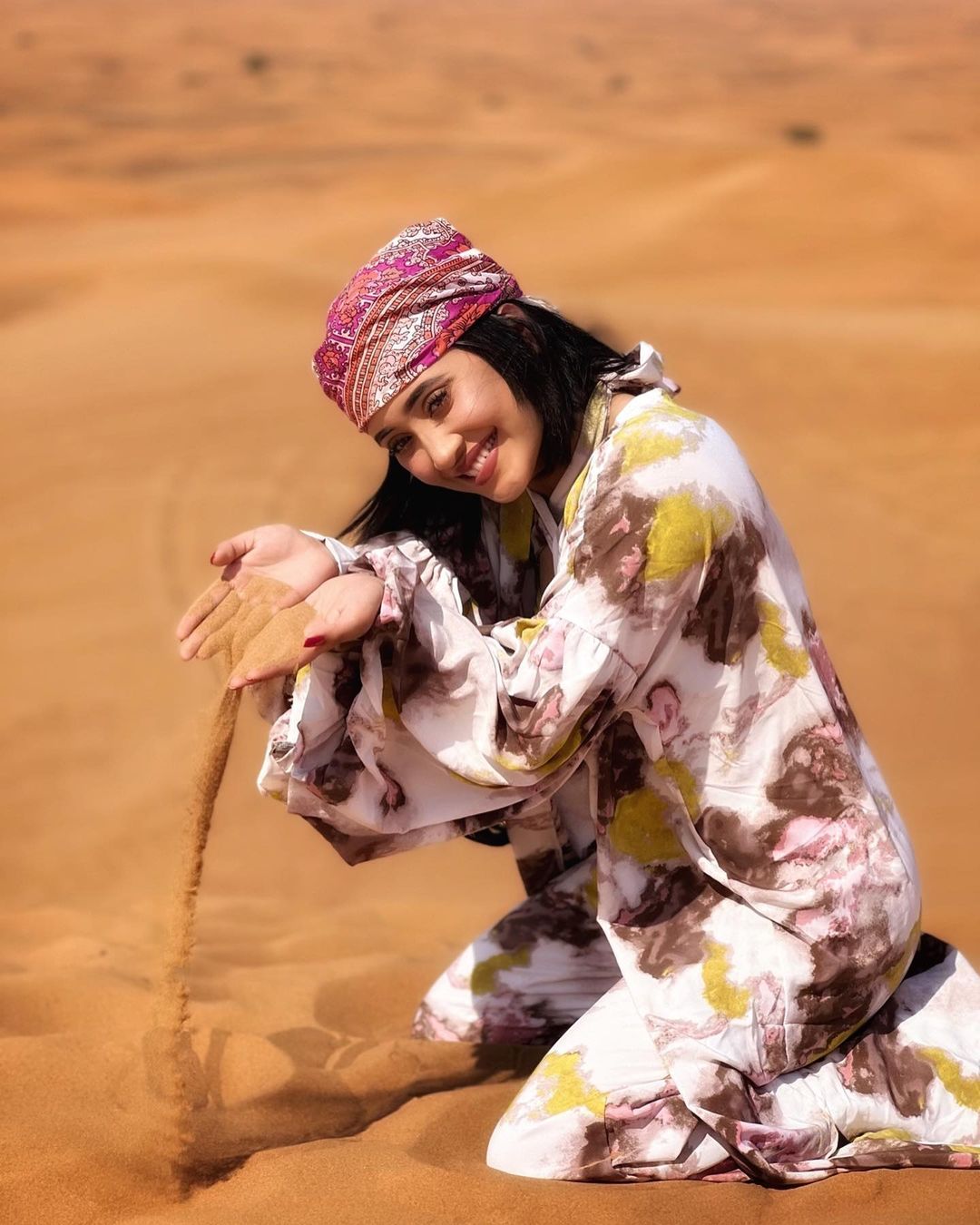  शिवांगी जोशी रेगिस्तान में बैठकर अपनी खूबसूरत स्माइल दिखा रही हैं. वह रेगिस्तान की रेत से खेलते हुए भी नजर आ रही हैं. (फोटो साभारः Instagram @shivangijoshi18)