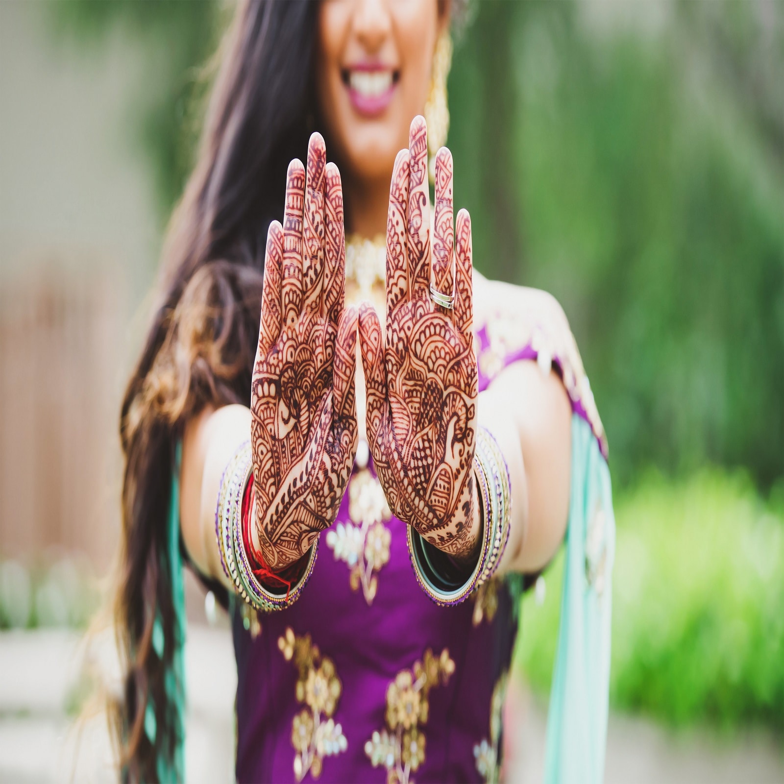 Photo of Intricate hand mehndi design with bride and groom portrait