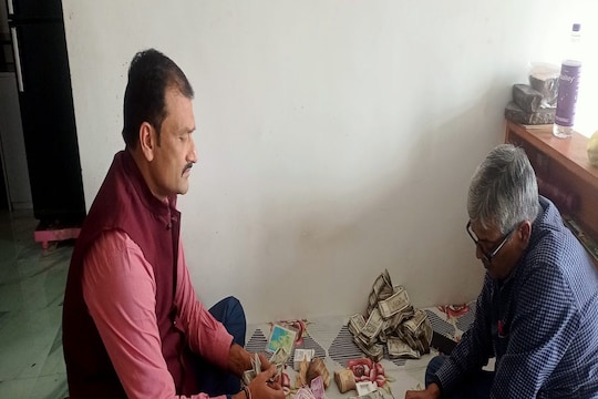 रोहतास के अधिकारी के घर रेड के दौरान पैसे का मिलान करती विजिलेंस की टीम 