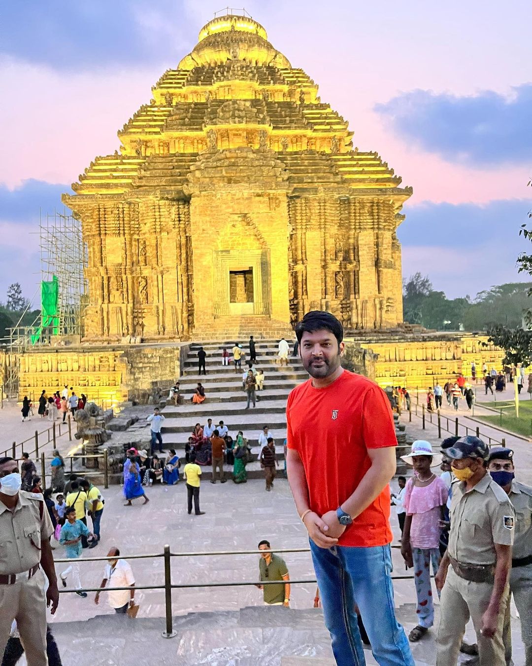 कपिल शर्मा ने पहले कोणार्क मंदिर में भगवान सूर्य के दर्शन किए. उन्होंने इसकी एक तस्वीर शेयर की. इस तस्वीर के बैकग्राउंड में मंदिर दिख रहा है. कपिल ने लाल रंग की टी-शर्ट और ब्लू डेनिम पहनी हुई है. (फोटो साभारः Instagram @kapilsharma)