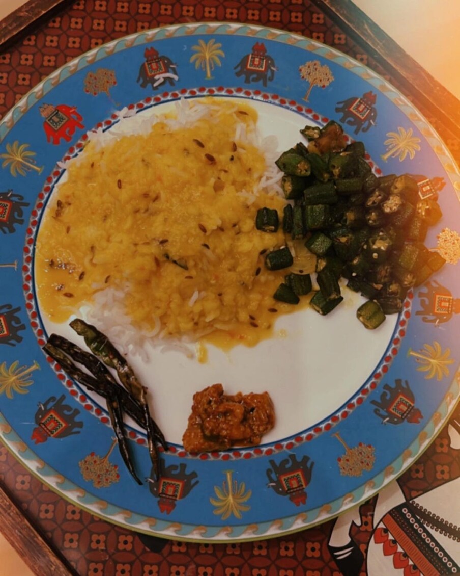  करिश्मा कपूर ने अपनी खाने की थाली की भी झलक दिखाई है, जिसमें दाल, चावल, भिंडी और अचार के साथ भुनी हुई मिर्च शामिल हैं. (फोटो साभारः Instagram @therealkarismakapoor)
