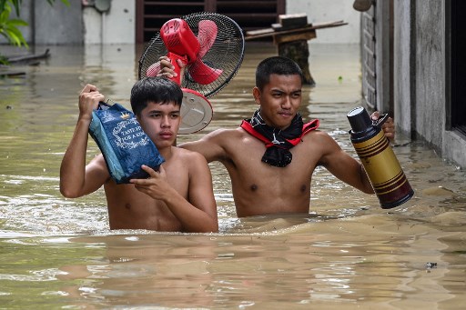  मनीला के उत्तर में स्थित बुलाकान प्रांत के गवर्नर डेनियल फर्नांडो ने कहा कि बाढ़ के पानी में फंसे लोगों की मदद के लिये नाव में सवार पांच राहतकर्मियों की मौत तब हो गई. जब एक दीवार उन पर गिर गई. Photo-AFP