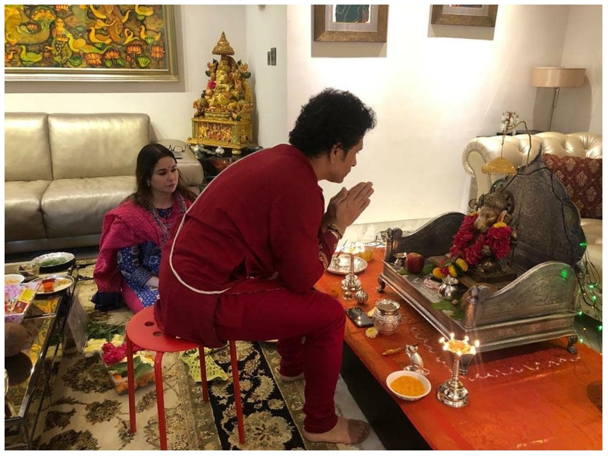  सचिन के घर का लिविंग रूम सफेद और भूरे रंग के रंगों से रंगा है, जो वॉर्म और आकर्षक वाइब्स देता है. उसमें रंगीन कुशन के साथ आलीशान सोफे शामिल हैं, जो इसे और अधिक जीवंत बनाते हैं. चमकदार क्रीम रंग के संगमरमर के फर्श को एक बड़ी चमड़े की कुर्सी, कई हाथीदांत लैंप, और सचिन तेंदुलकर के सभी पुरस्कारों को कमरे में बड़े करीने से सजाया गया है. (Sachin Tendulkar/Instagram)
