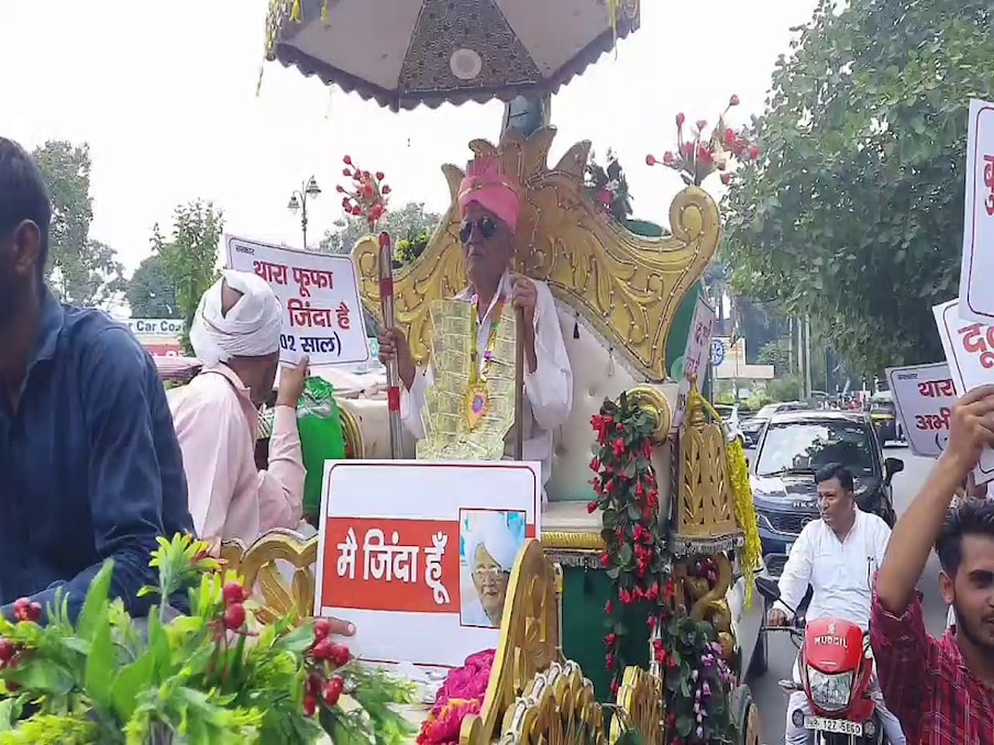  हरियाणा में बुढ़ापा पेंशन कटने के कई मामले सामने आ रहे हैं, लेकिन सरकार दावा कर रही है कि उसने किसी भी बुजुर्ग की पेंशन नहीं काटी है. रोहतक के गांव गांधरा के रहने वाले 102 साल के बुजुर्ग दुलीचंद ने सरकार और प्रशासन को आईना दिखाने के लिए एक अजब-गजब काम कर डाला. बुजुर्ग दुलीचंद दूल्हे की तरह वेशभूषा पहनकर बैंड-बाजा-बारात लेकर और रथ में बैठकर रोहतक जिला मुख्यालय पर पहुंच गया.