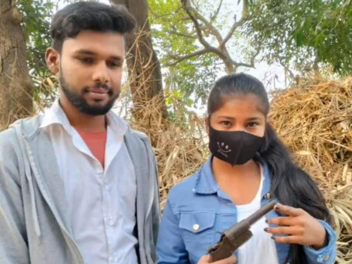 चेहरे पर मास्क लगाए लड़की ने अपने प्रेमी के साथ देशी कट्टा को पकड़कर  सोशल मीडिया प्लेटफार्म पर फोटो शेयर की (News18 Hindi)