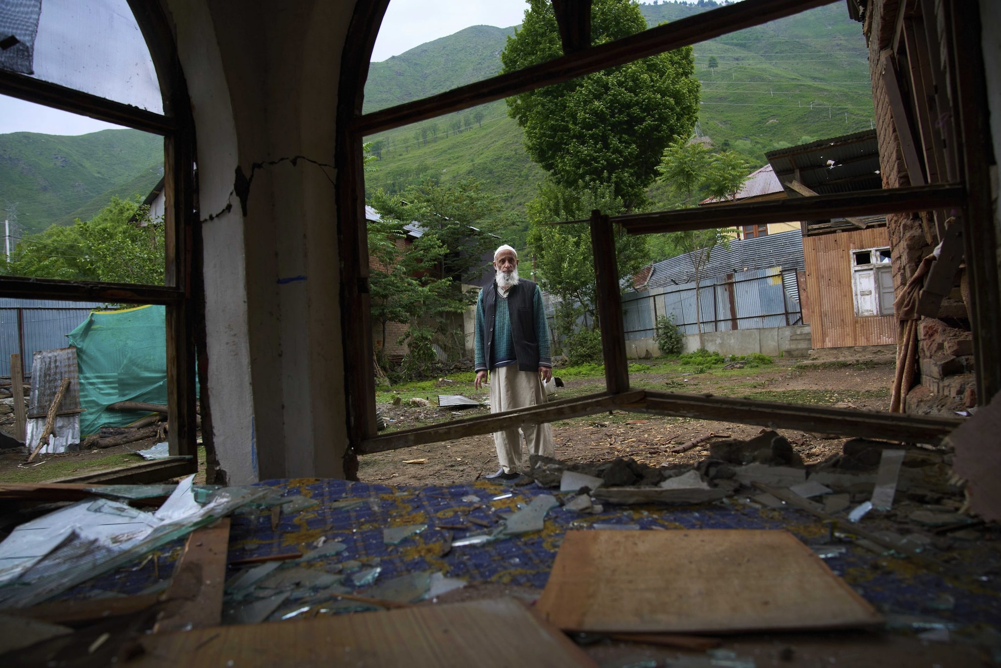 An elderly Kashmiri villager Mohammad Saleem inspects a damaged house after overnight shelling from Pakistan at Gingal village in Uri district, Indian controlled Kashmir, Friday, May 9, 2025. (AP Photo/Dar Yasin)