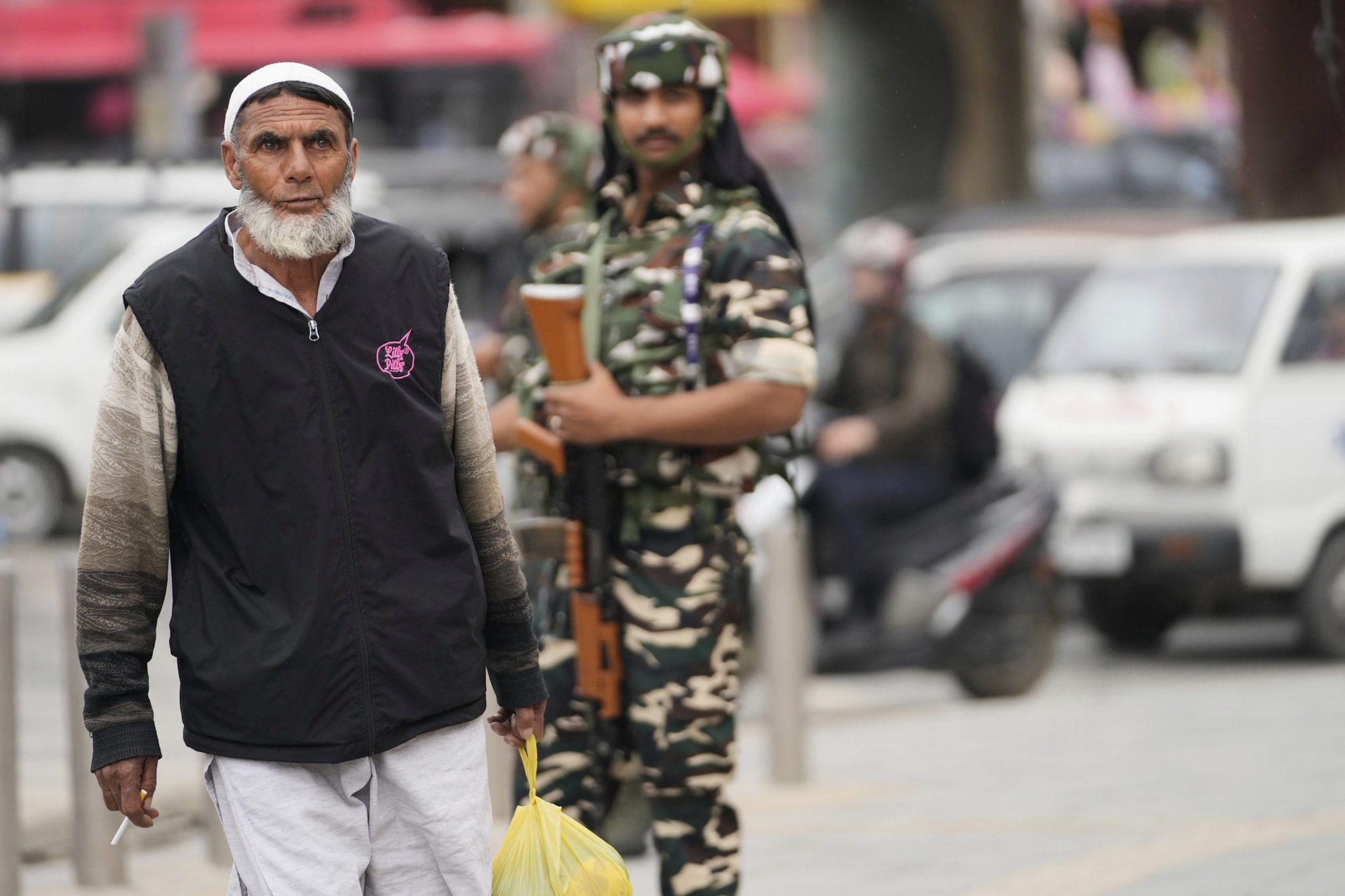 Indian soldiers stand guard as a Kashmiri  Muslim man walks in Srinagar, Indian controlled Kashmir, Friday, May 9, 2025. (AP Photo/Mukhtar Khan)