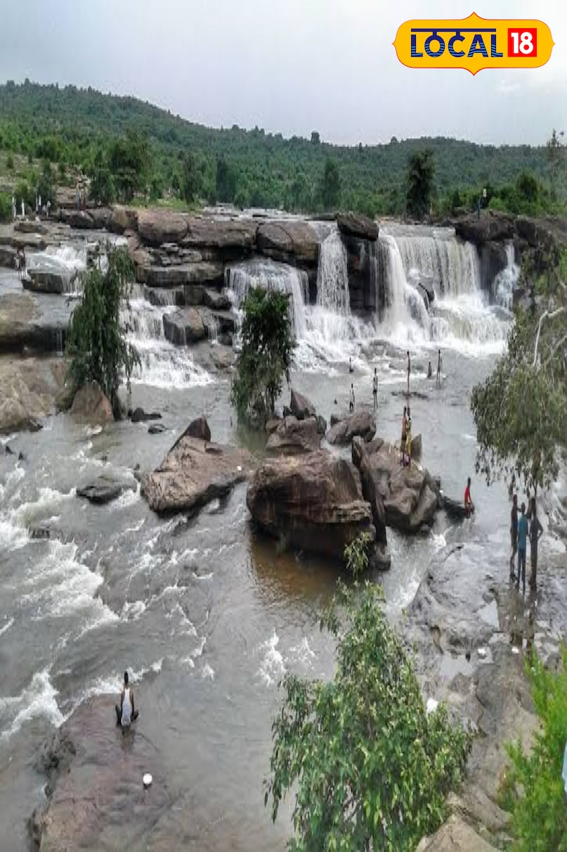 Locals and tourists beat the heat while bathing under the waterfall