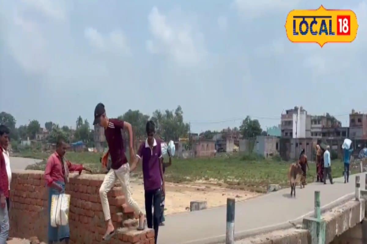 नीचे उफनती नदी, सामने टूटा हुआ पुल, दीवार फांदकर बच्चे पार कर रहे रास्ता...