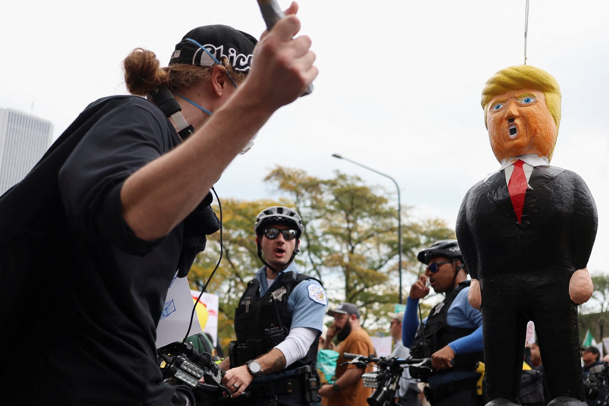 A demonstrator hits a pinata, depicting US President Donald Trump during a A demonstrator hits a pinata, depicting US President Donald Trump during a