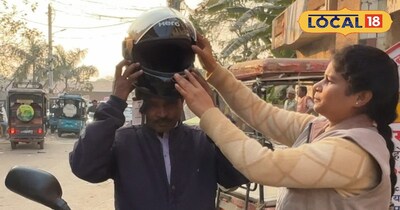 लोगों को हेलमेट पहनाती अनुपमा द्विवेदी 