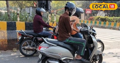 धूप से बचने के लिए छांव में खड़े लोग