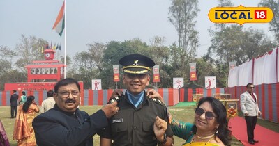 माता पिता अपने बेटे को मेडल देते 