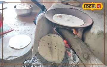 मिट्टी चूल्हे में रोटी बनाती गृहिणी 