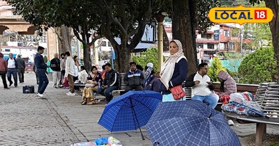 नैनीताल में बूंदाबादी के बीच छाता बेचती महिला
