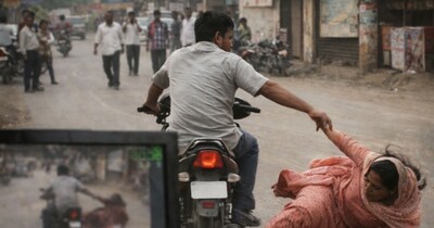 बाइक पर पीछे बैठी महिला अचानक सड़क पर गिरती है.  (फोटो एआई से बनाई गई)