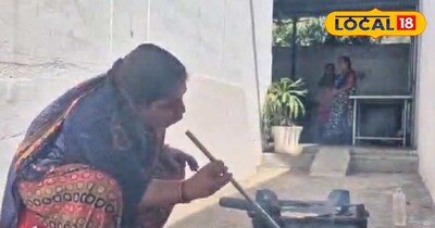 चूल्हे में रोटी बनाती महिला.