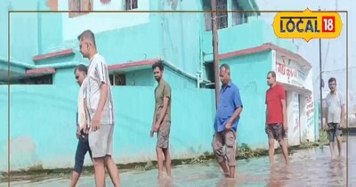 सड़क पर जलजमाव में चलते हुए लोग