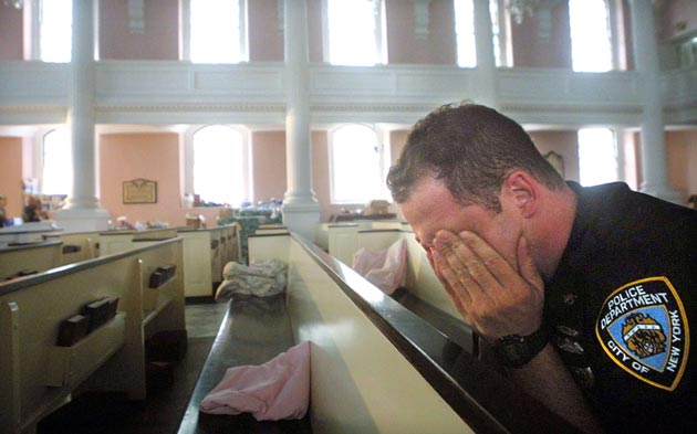 NYPD police officer Ken Radigan rubs his eyes after briefly sleeping in a pew at St. Paul's Episcopal Chapel, near the site of the World Trade Center attack, September 21, 2001 in New York City. The chapel is serving as a relief area for rescue workers.