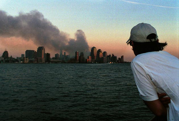 A man watches smoke emit from the former site of the World Trade Center September 12, 2001 in Hoboken, NJ. Smoke filled the air all over lower Manhattan in the aftermath of Tuesday's terrorist attack and destruction of the World Trade Center.