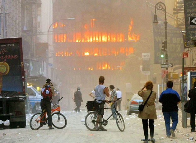 People walk in the street in the area where the World Trade Center buildings collapsed September 11, 2001 after two airplanes slammed into the twin towers in a suspected terrorist attack.