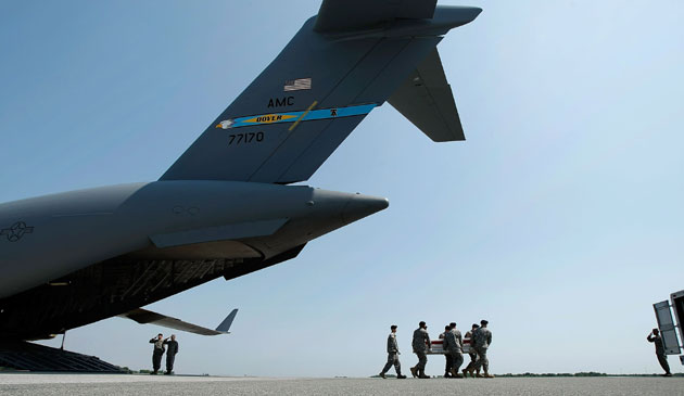 Members of a US Army carry team carries the flag-draped transfer case containing the remains of US Army Specialist Lukasz Saczek of Lake in the Hills, Ill., from a C-17 to an waiting vehicle during a dignified transfer on the tarmac at Dover Air Force Base May 12, 2009 in Dover, Delaware. Assigned to Company D, 1st Battalion, 178th Infantry, Saczek was killed in Afghanistan May 10 in a non-combat related incident.