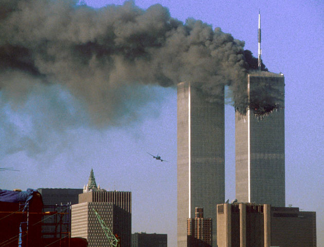 Hijacked United Airlines Flight 175 (L) flies toward the World Trade Center twin towers shortly before slamming into the south tower (L) as the north tower burns following an earlier attack by a hijacked airliner in New York City September 11, 2001. The stunning aerial assaults on the huge commercial complex where more than 40,000 people worked on an ordinary day were part of a coordinated attack aimed at the nation's financial heart. They destroyed one of America's most dramatic symbols of power and financial strength and left New York reeling.